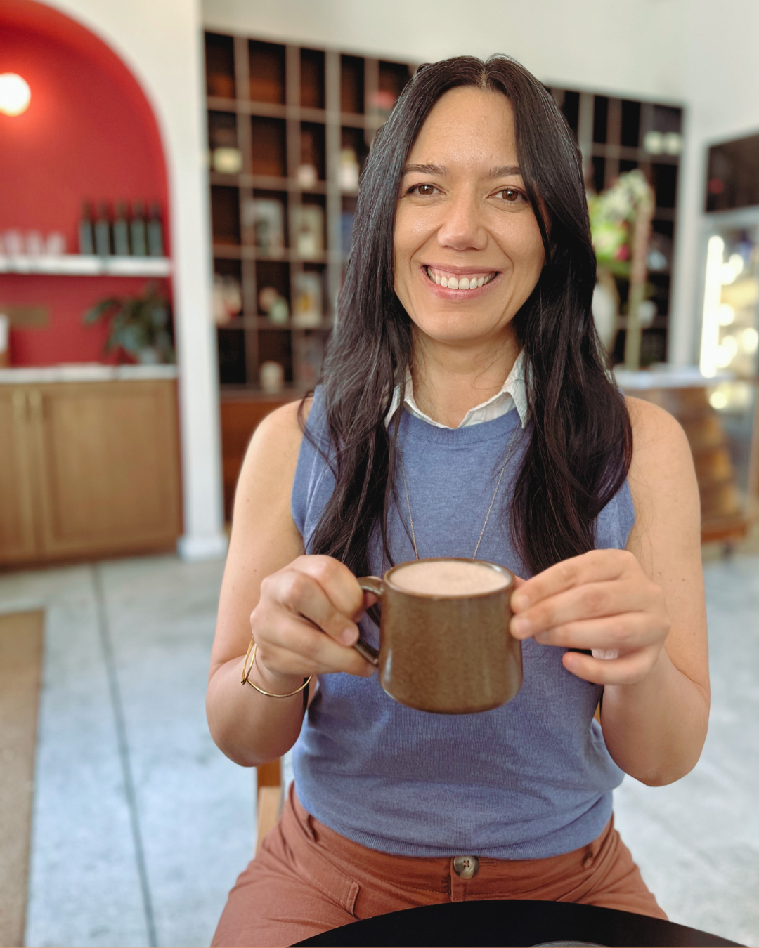 Paola Mendez holding a latte at a Coral Gables cafe, the no-phones coffee date self-care gift
